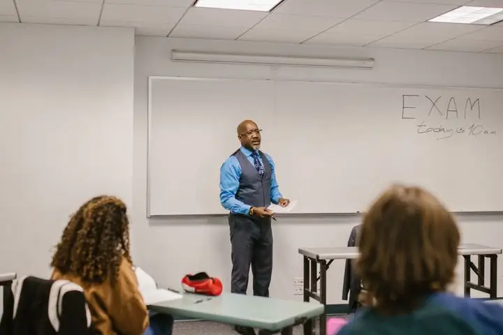 Professor giving a lecture to students in a university classroom.