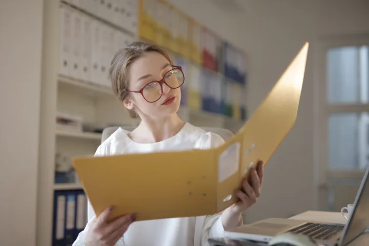 Auditor reviewing documentary evidence in a focused office workspace.