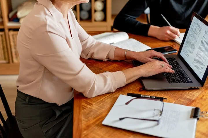 Executive support professional preparing a decision brief with a senior colleague.