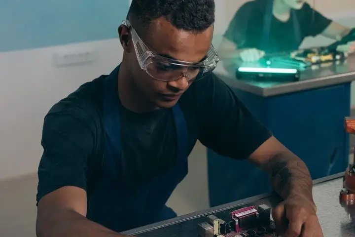 Engineer assembling and testing electronic hardware in a laboratory.