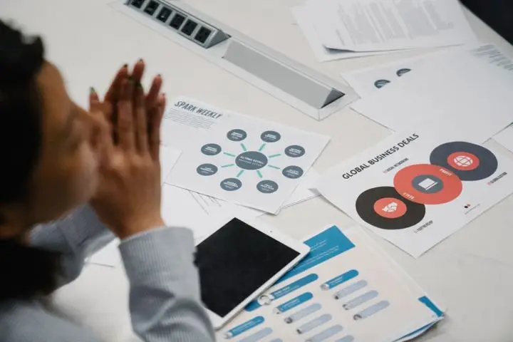 Businesswoman reviewing analytics charts and documents during a meeting.