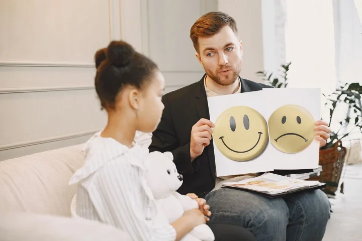 Therapist using picture-supported communication with a child during a clinical session.