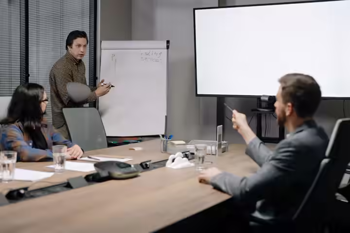 Colleagues engaged in a presentation meeting inside a modern office setting.