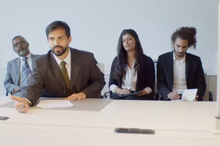 A diverse group of business professionals in a modern office setting, focusing on teamwork.