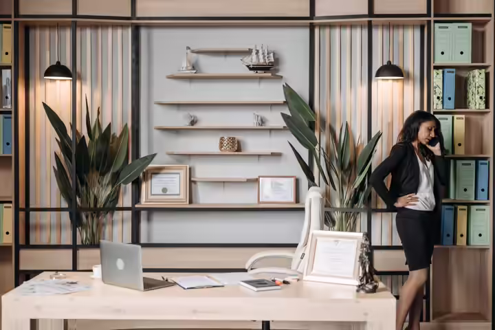 Businesswoman on phone in stylish office, showcasing professionalism and modern work environment.