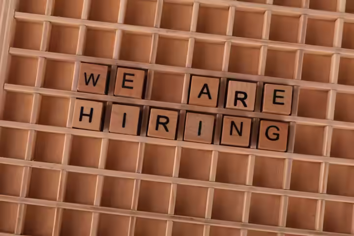 Wooden tiles on a board forming the phrase 'We Are Hiring', ideal for job announcements.