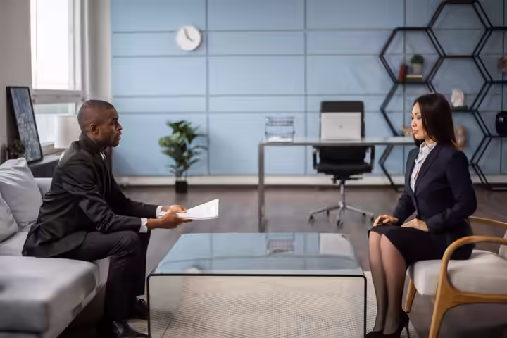 Business professionals having a meeting in a modern office setting, showcasing diversity and collaboration.