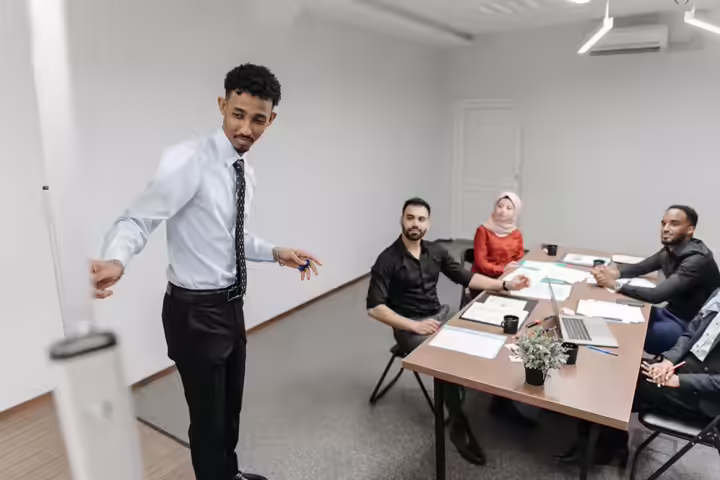 A diverse team collaborates in a modern office setting, showcasing teamwork and communication.
