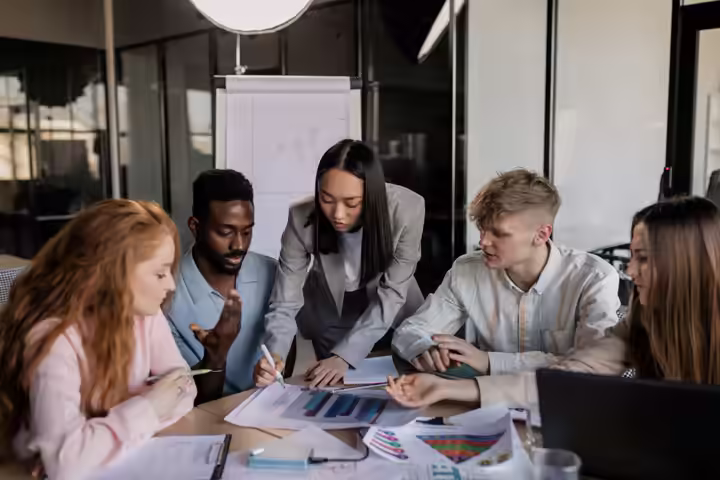 A diverse group of professionals engaged in a collaborative business strategy meeting in a modern office.