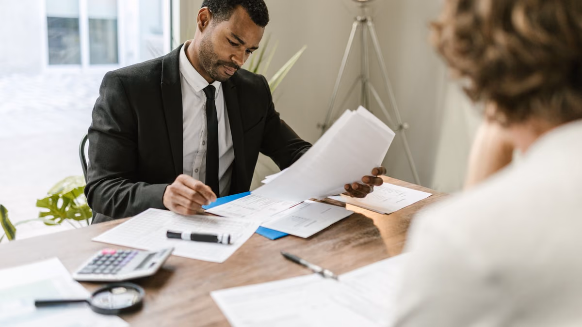 Two business professionals reviewing papers together at an office desk.
