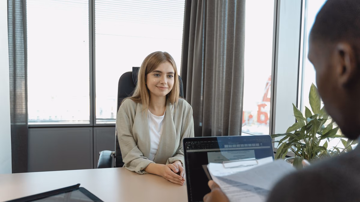 A candidate sits confidently in an office interview.