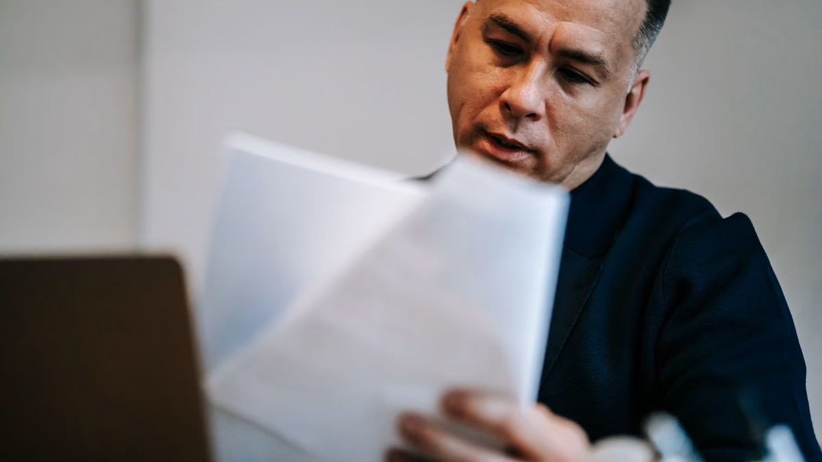 A professional concentrating on paperwork at his workstation.